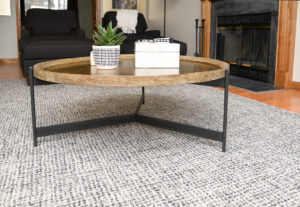 Iron and Wood Round Coffee Table on a black rug - Interior Design Near Me